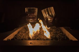 Toasting drinks by fire pit.